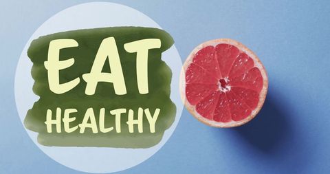 Eat healthy message with halved grapefruit on blue background