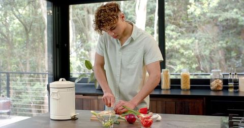 Young Man Prepping Vegetables in Bright Modern Kitchen
