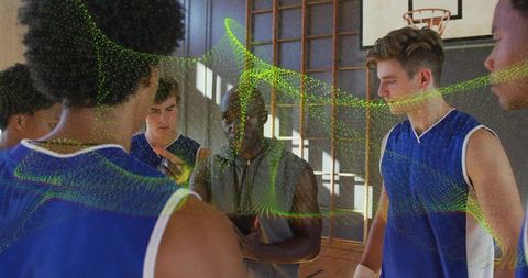 Coach Strategizing with Team Using Tablet in Gym