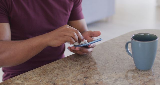 Person Cleaning Smartphone While Sitting at Table with Mug - Download Free Stock Images Pikwizard.com