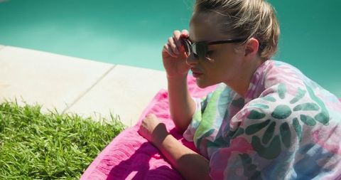 Woman relaxing by pool in summer fashion