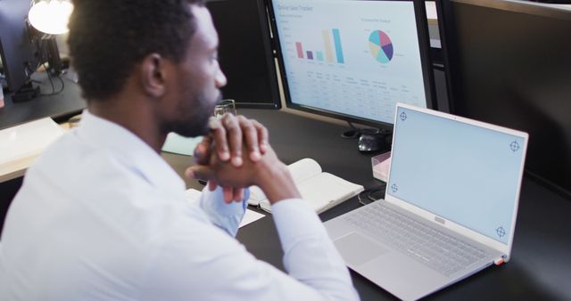 Focused Businessman Looking at Data Analytics on Computer Screens in Office - Download Free Stock Images Pikwizard.com