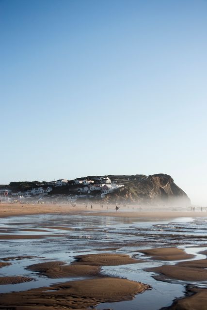 Serene Morning at Beach with Distant Houses and Cliffs - Download Free Stock Images Pikwizard.com