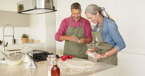 Senior couple baking together in modern home kitchen