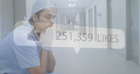 Exhausted clinician sitting in corridor with hands to face and social likes overlay