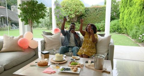 Joyful Mature Couple Celebrating with Champagne and Cake at Home