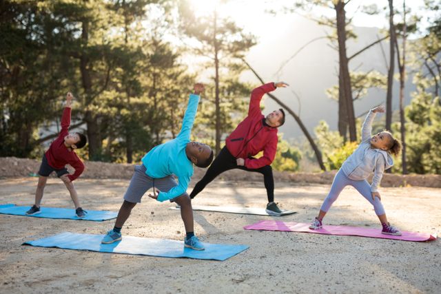 Group of children practicing yoga with a coach in a scenic outdoor setting. Ideal for promoting fitness, healthy lifestyle, outdoor activities, and children's exercise programs.