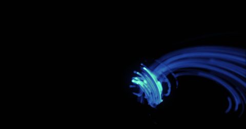 A mesmerizing display of abstract blue light trails flowing seamlessly over a black background. The radiant curves of light create an artistic and dynamic feeling, suitable for digital artwork, graphic design elements, or background images. Ideal for presentations, creative projects, or showcasing futuristic concepts in technology and innovation.