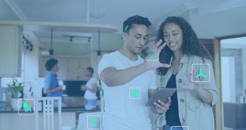 Young couple using tablet to control smart home energy and renewable tech in modern kitchen