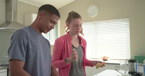 Young couple preparing banana smoothie in bright kitchen, healthy morning routine inspiration