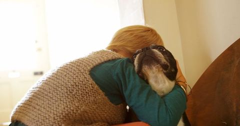 Boy Embracing French Bulldog with Tenderness at Home