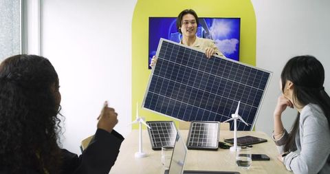 Diverse coworkers discussing sustainable energy solutions in modern office