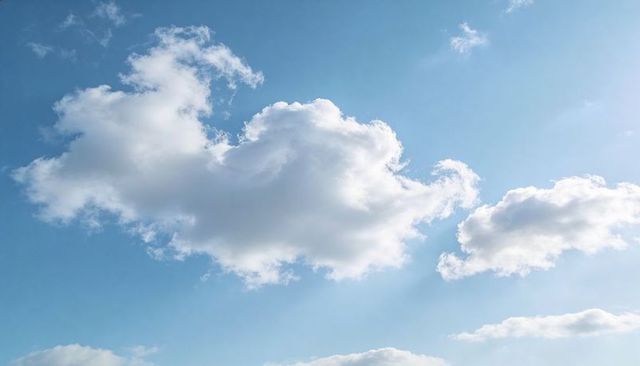 Sunlit Cumulus Cloud Drifting Across Clear Blue Sky With Soft Sun Rays