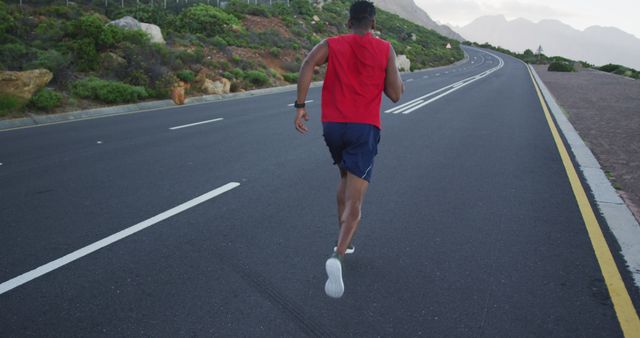 Rear view of african american man running on the road. fitness sports and healthy lifestyle concept