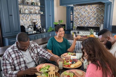 Friends Enjoying Casual Meal Around Kitchen Table