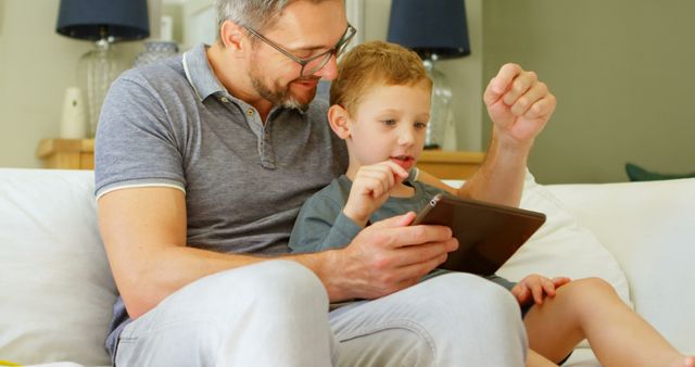 Happy Father and Son Using Digital Tablet at Home - Download Free Stock Images Pikwizard.com