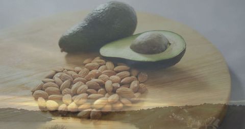 Avocado and Almonds on Wooden Board with Overlay Sunset Scene