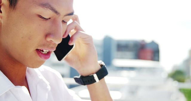 Young Asian Man Having a Phone Call Outdoors - Download Free Stock Images Pikwizard.com