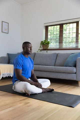 Man Practicing Mindfulness Meditation at Home on Yoga Mat