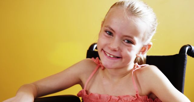 Smiling Girl in Wheelchair Against Yellow Wall - Download Free Stock Images Pikwizard.com