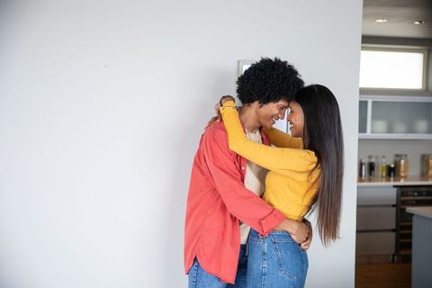 Affectionate couple embracing in modern kitchen with warm decor