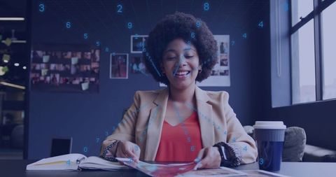 Young woman reading magazine with augmented reality overlay at modern coworking desk