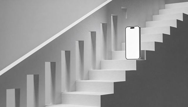 Smartphone standing on minimalist staircase showing geometric monochrome contrast