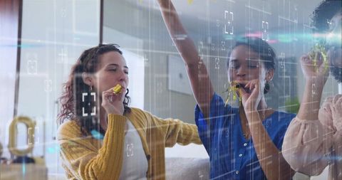 Friends celebrating on couch blowing party horns with gold balloon and HUD overlay