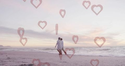 Senior Couple Strolling on Beach Amidst Hearts at Sunset