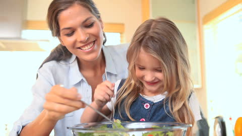 Mother and Daughter Joyfully Preparing Salad Together at Home