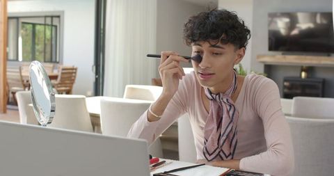 Male influencer skillfully applying makeup at home