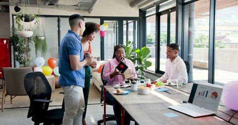 Team colleagues celebrating with gifts during office party