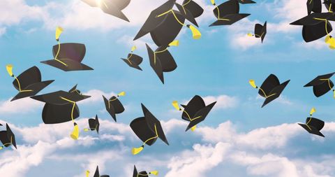 Celebratory graduation hats flying in clear blue sky