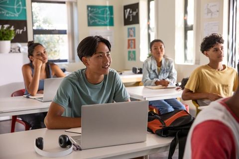 High School Students Engaging with Laptops and Collaboration in Modern Classroom Learning