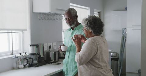 Mature African American Couple Enjoying Morning Drinks in Kitchen