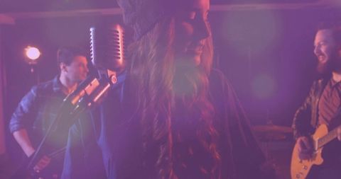 Live music performance with singer and band in purple haze lighting