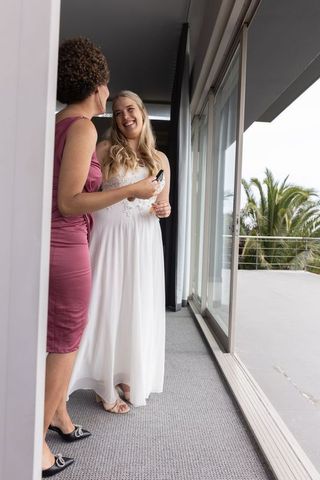 Bride with Bridesmaid Chatting by Sliding Door in Elegant Setting