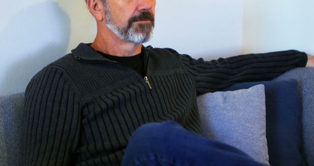 Pensive Mature Man Sitting on Sofa with Thoughtful Expression - Download Free Stock Images Pikwizard.com