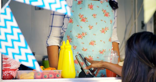 Woman Taking Order at Food Truck in Floral Apron - Download Free Stock Images Pikwizard.com