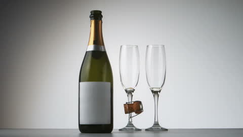 Champagne Bottle with Cork and Flutes on Table