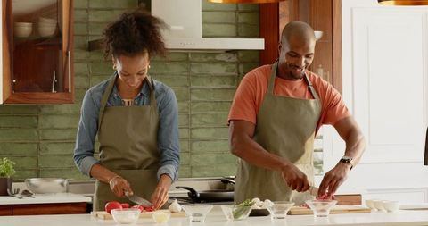 Smiling Couple Enjoys Cooking in Stylish Kitchen