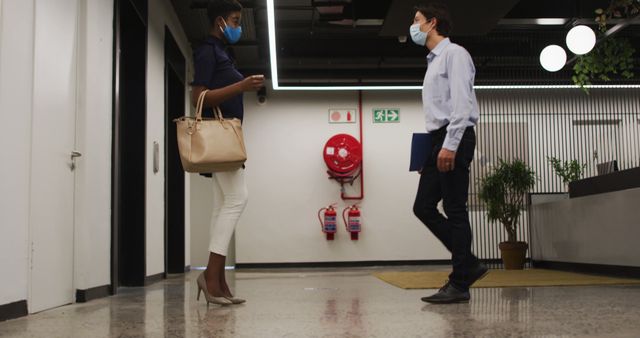 Colleagues Wearing Face Masks Talking in Modern Office Lobby - Download Free Stock Images Pikwizard.com