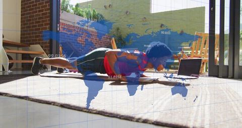 Man holding forearm plank at home with laptop and world map overlay for virtual fitness
