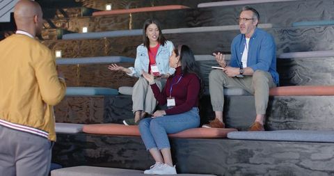 Diverse team discussing ideas on tiered cushions in modern collaborative workspace