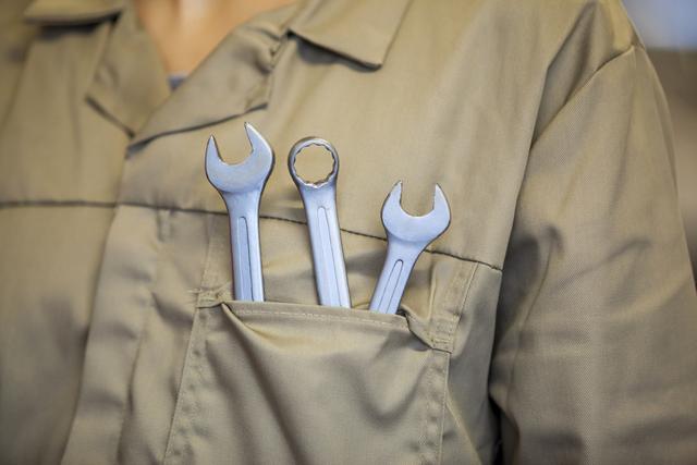 Mid-section of female mechanic with tools in pocket - Download Free Stock Photos Pikwizard.com