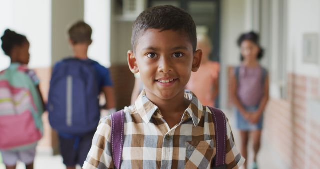 Image of happy biracial boy standing at school corridor - Download Free Stock Photos Pikwizard.com