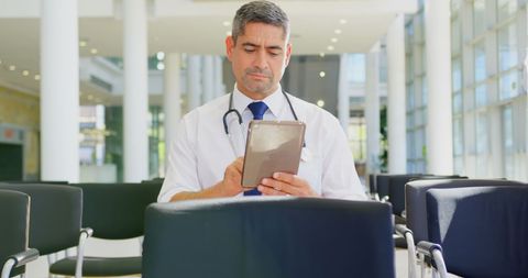 Caucasian Male Doctor Using Tablet in Modern Conference Setting - Download Free Stock Images Pikwizard.com