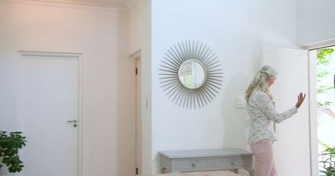 Senior woman entering bright home interior