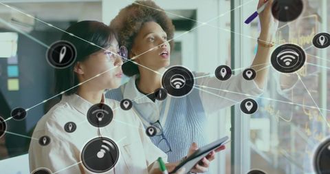 Diverse Colleagues Exploring Network Icon Overlay in Modern Office - Download Free Stock Images Pikwizard.com