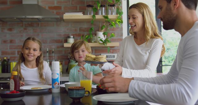 Happy Family Having Breakfast and Smiling Together - Download Free Stock Images Pikwizard.com